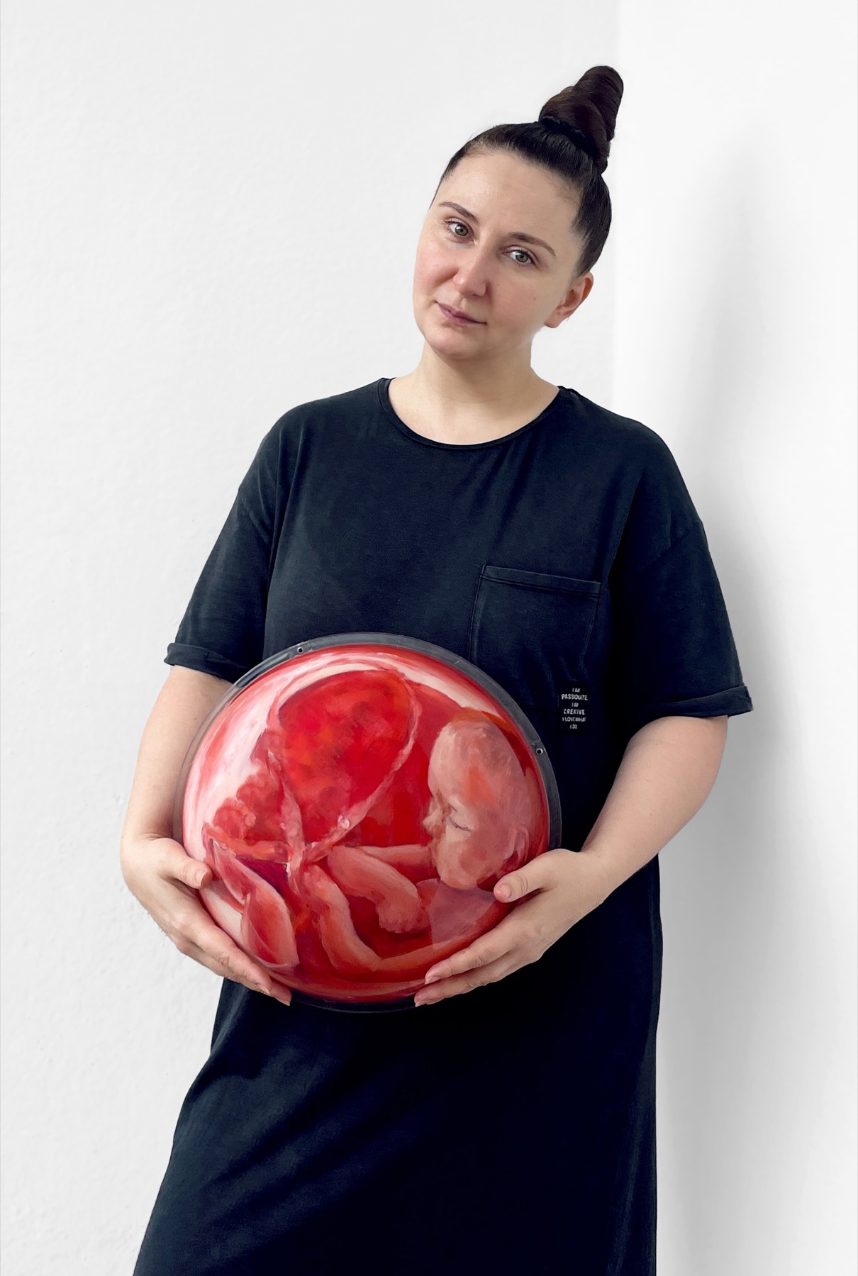 Leah Larisa Bunshaft holding a round artwork